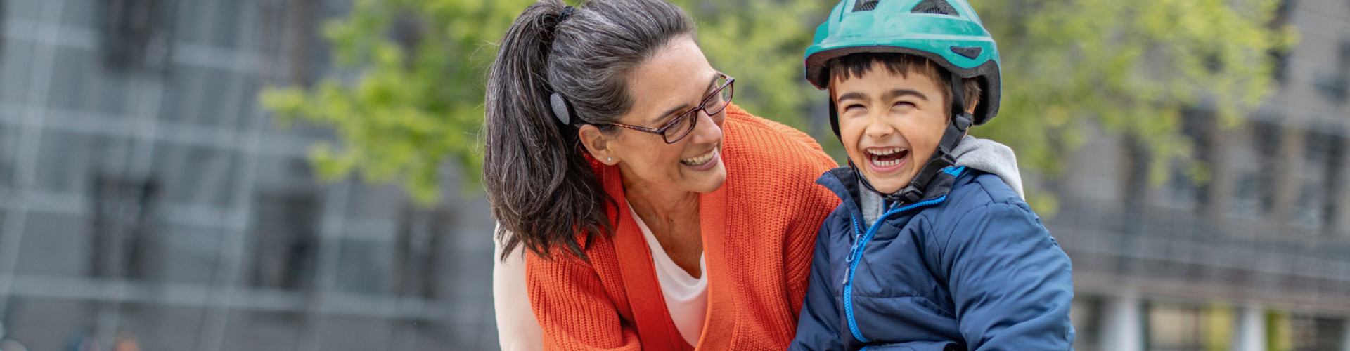 RONDO 3 user laughing with a child as she helps him skateboard.