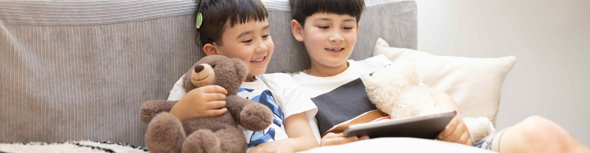 AudioKey 3 - Enjoy Peace of Mind A young SONNET 3 user streaming sound directly from a tablet as he watches a video with his brother