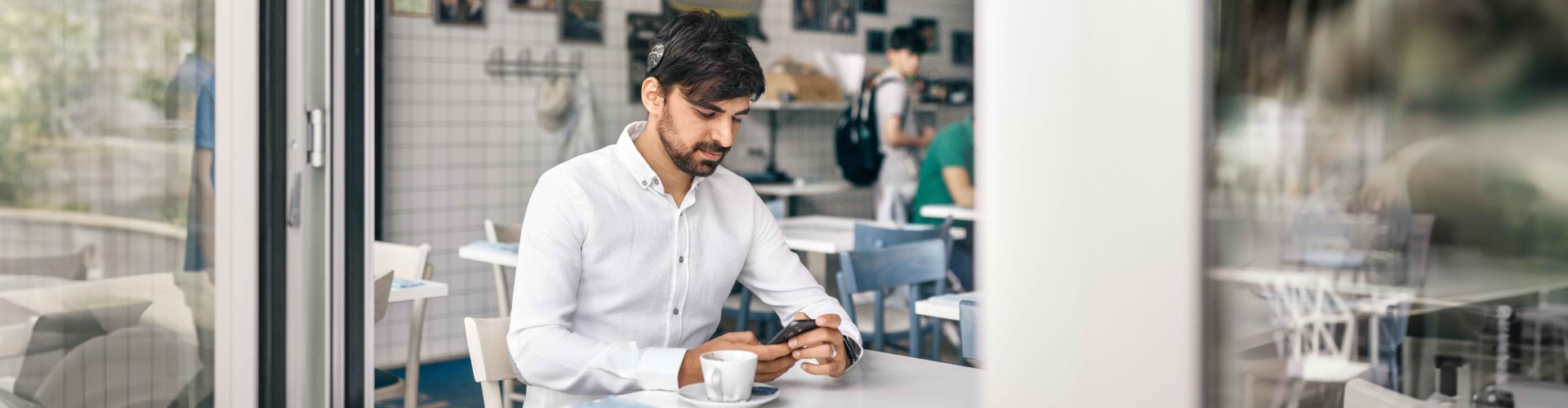 AudioKey 3 - Extended Statistics A SONNET 3 user sitting in a café checking his hearing statistics in the AudioKey 3 app