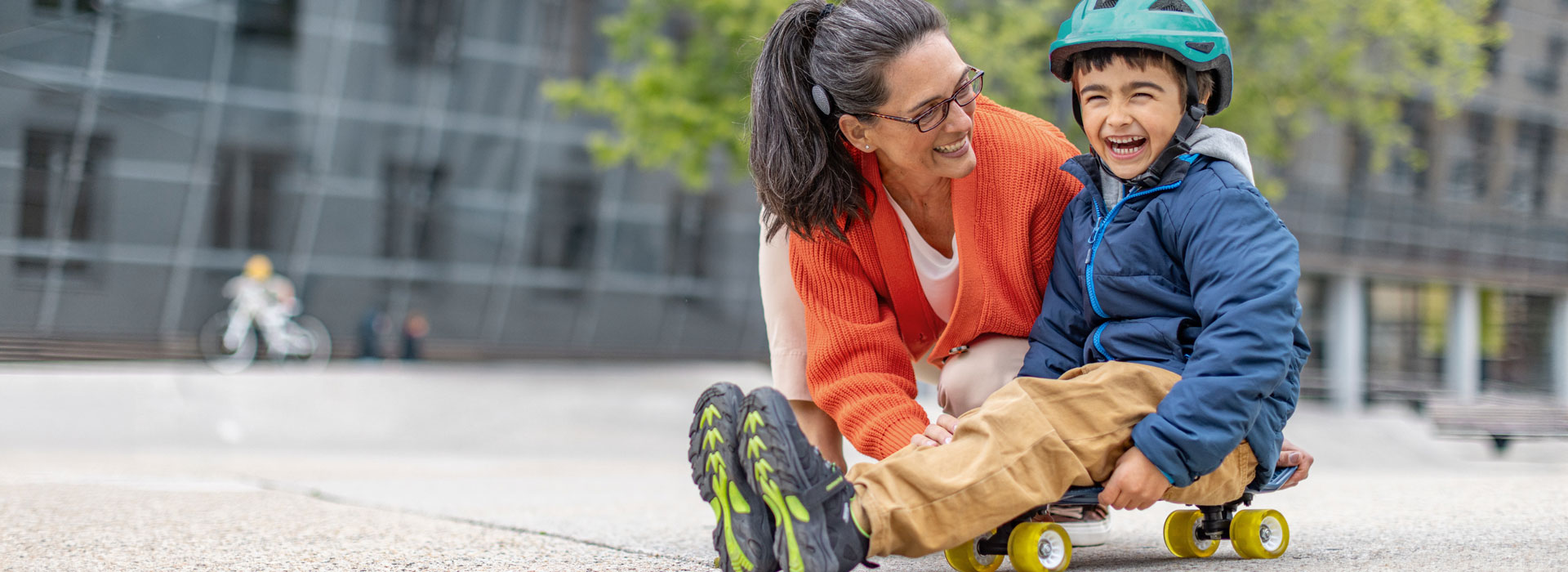 Mother laughing with her son on skateboard