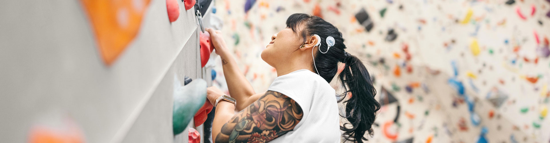 Klettererin mit CI in der Kletterhalle